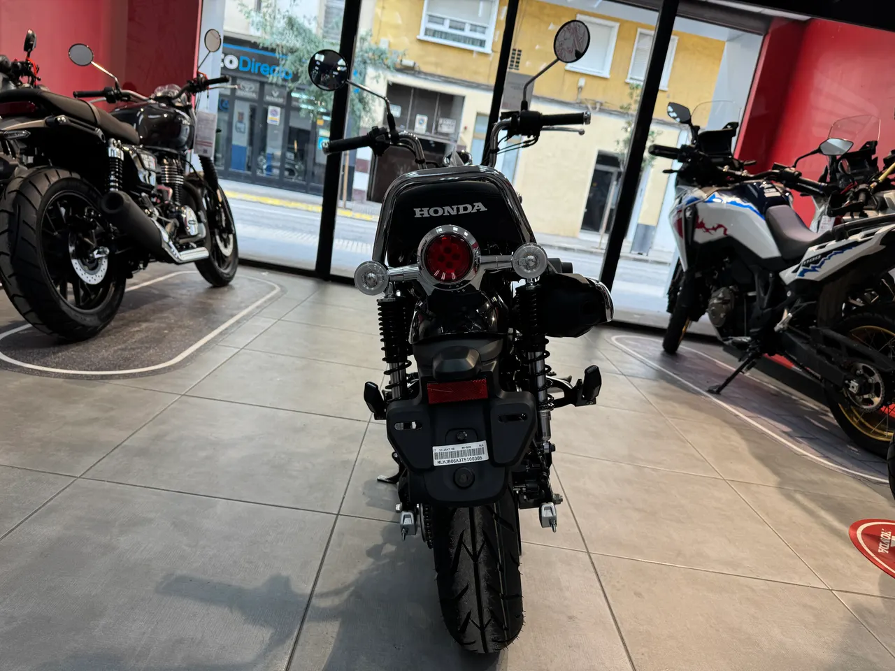 Parte trasera de una Honda Dax 125 negra perlada en un concesionario.