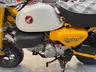 Moto Honda Monkey amarilla con tanque blanco y asiento a cuadros