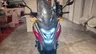 Vista frontal de una moto Honda NC750X de color rojo y gris con luces LED encendidas.