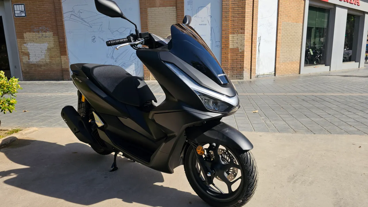 Honda PCX 125 NHA76 Gris Mate con cúpula ahumada oscura de estilo deportivo.