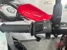 Detalle del manillar izquierdo de una Honda CRF300L con puño, controles de luces y bocina, y protector de mano rojo.