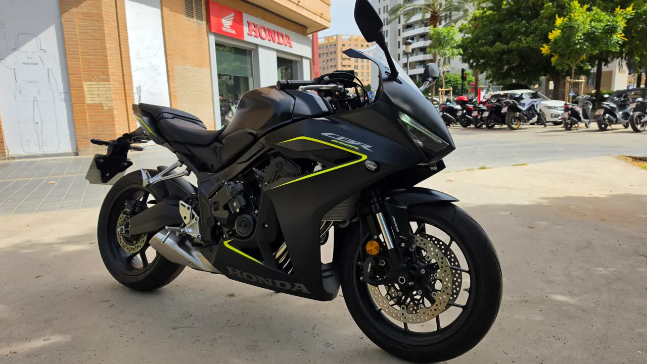 Honda CBR 650R negra con detalles amarillos aparcada frente a concesionario Honda