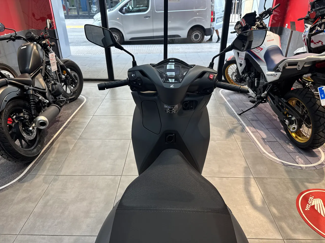 Vista frontal de una moto Honda SH 350i gris rock mate