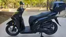 Honda SH350i negra con baúl en un parque