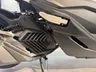 Detalle lateral de la Honda Forza 125 en color oscuro, mostrando la rejilla de ventilación
