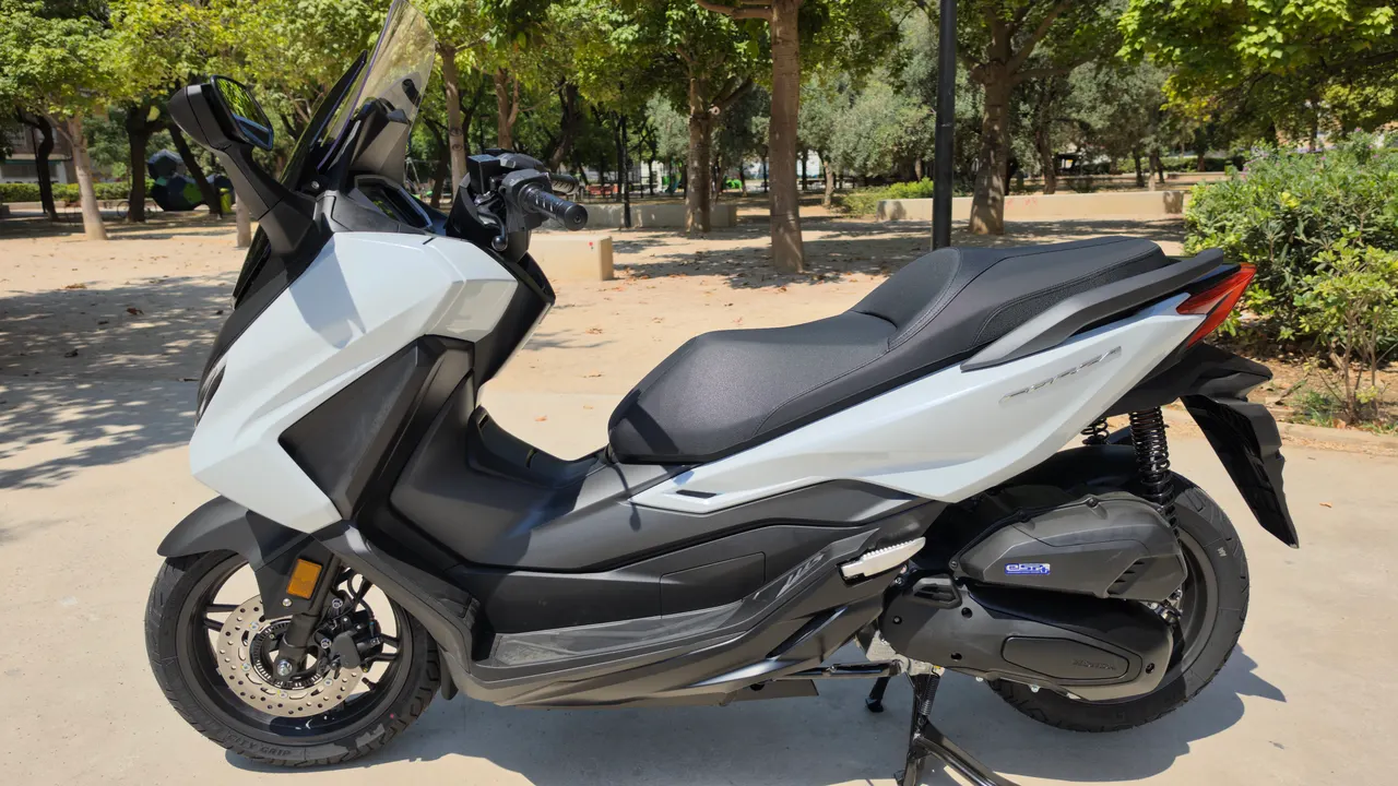 Scooter Honda Forza 125 blanco perlado aparcado en un parque