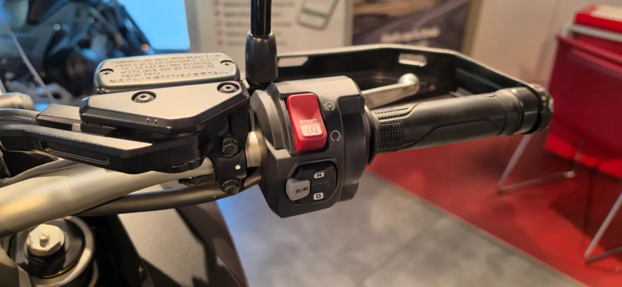 Detalle del manillar de una motocicleta con los controles de encendido y otros botones.