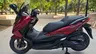 Scooter Honda Forza 350 rojo carnelian mate en un parque