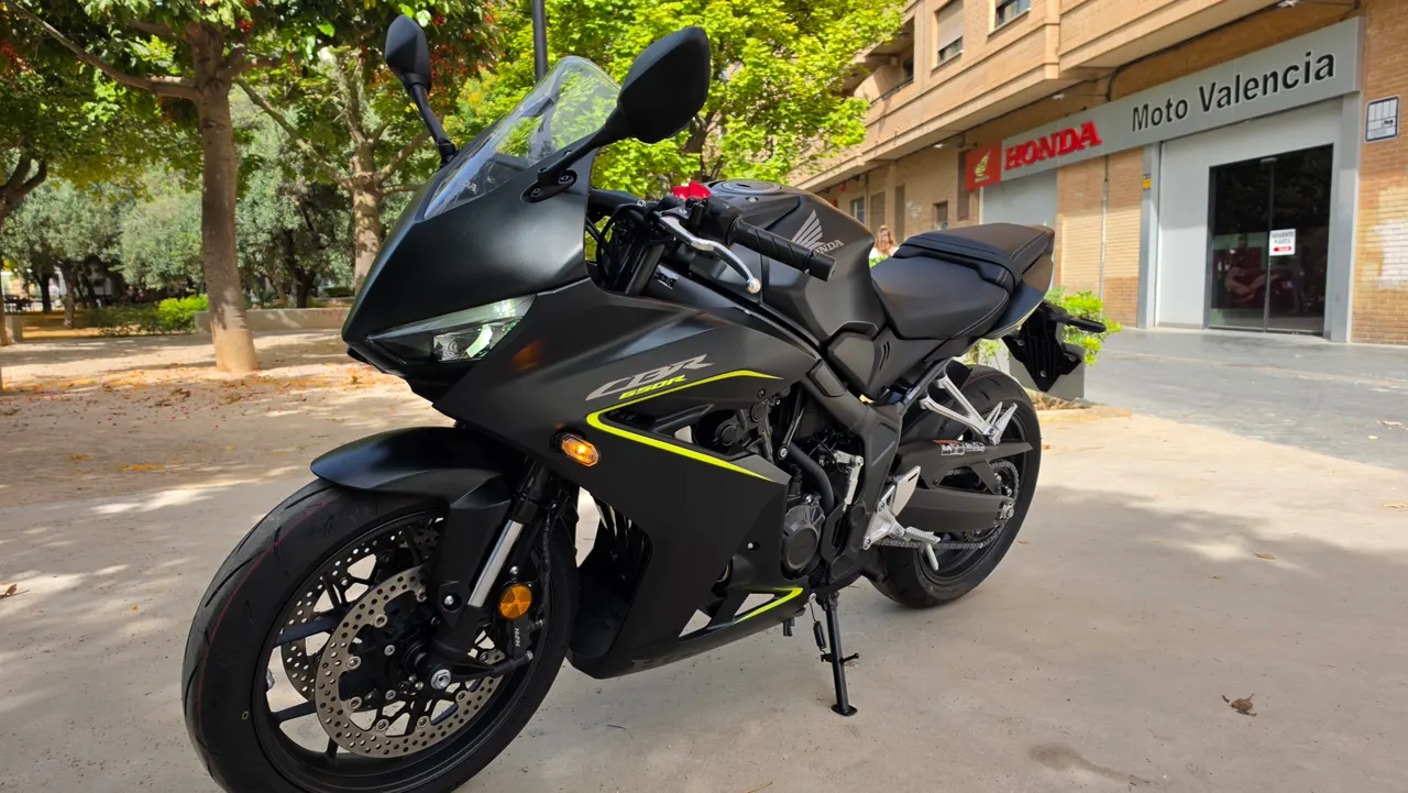 Honda CBR 650R negra mate con detalles amarillos, aparcada frente a concesionario Honda Moto Valencia.