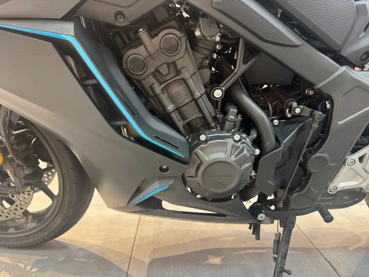 Detalle del motor de una moto Honda en color negro con líneas decorativas azules.
