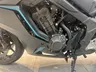 Detalle del motor de una moto Honda en color negro con líneas decorativas azules.