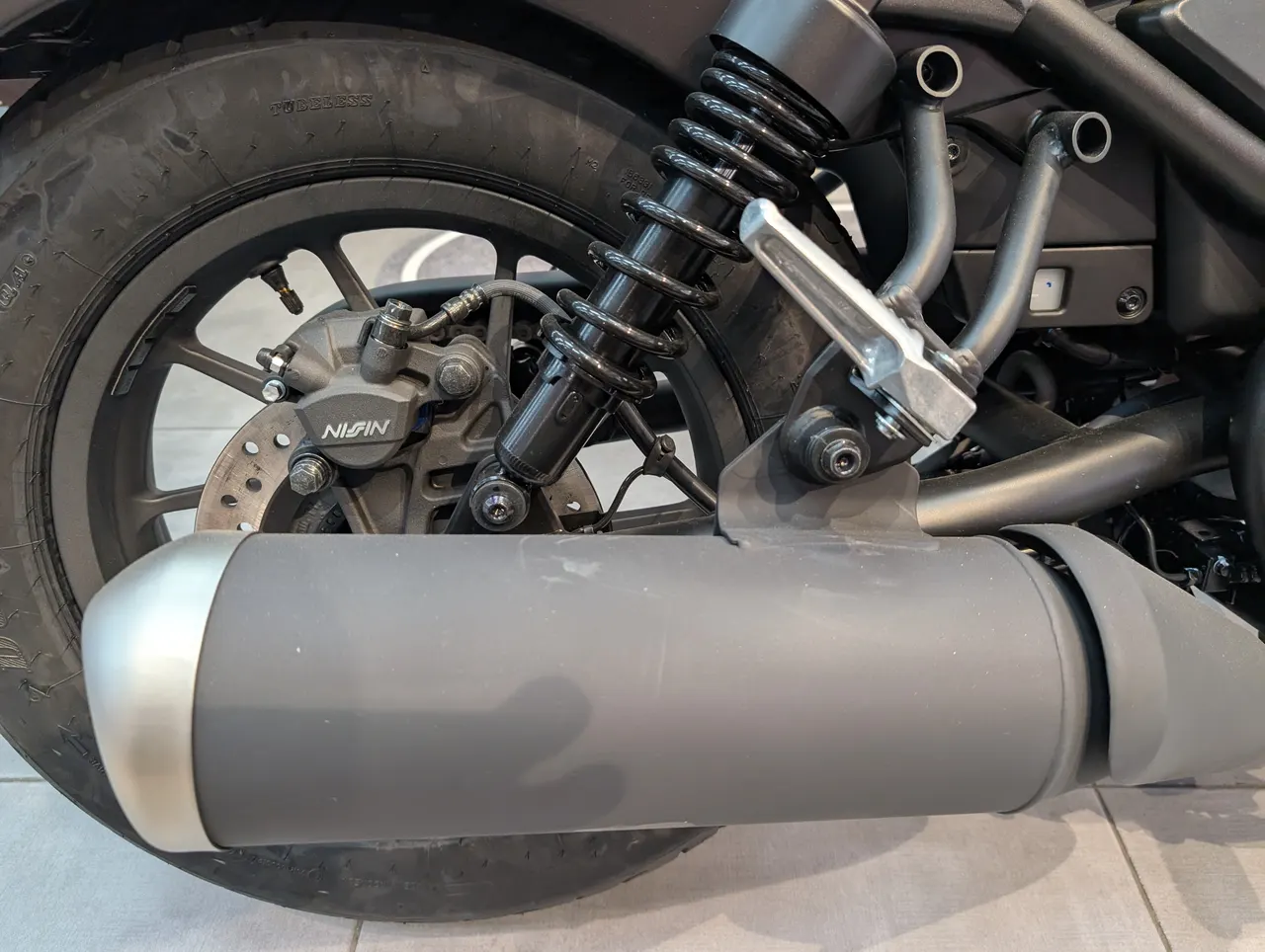 Rueda trasera, escape y freno de disco de una Honda Rebel 500 negra