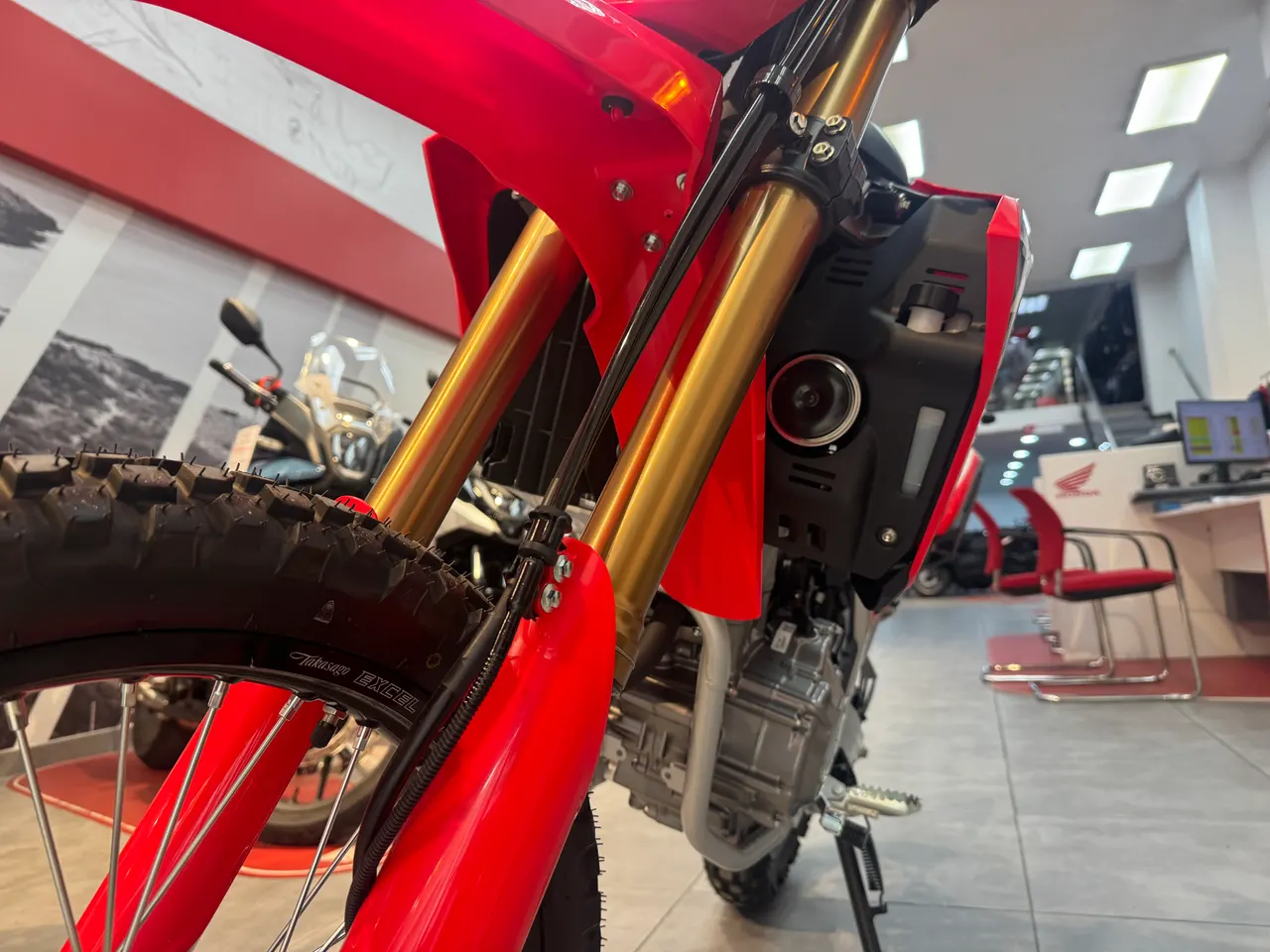 Horquillas doradas invertidas de una Honda CRF300L roja con sus protectores