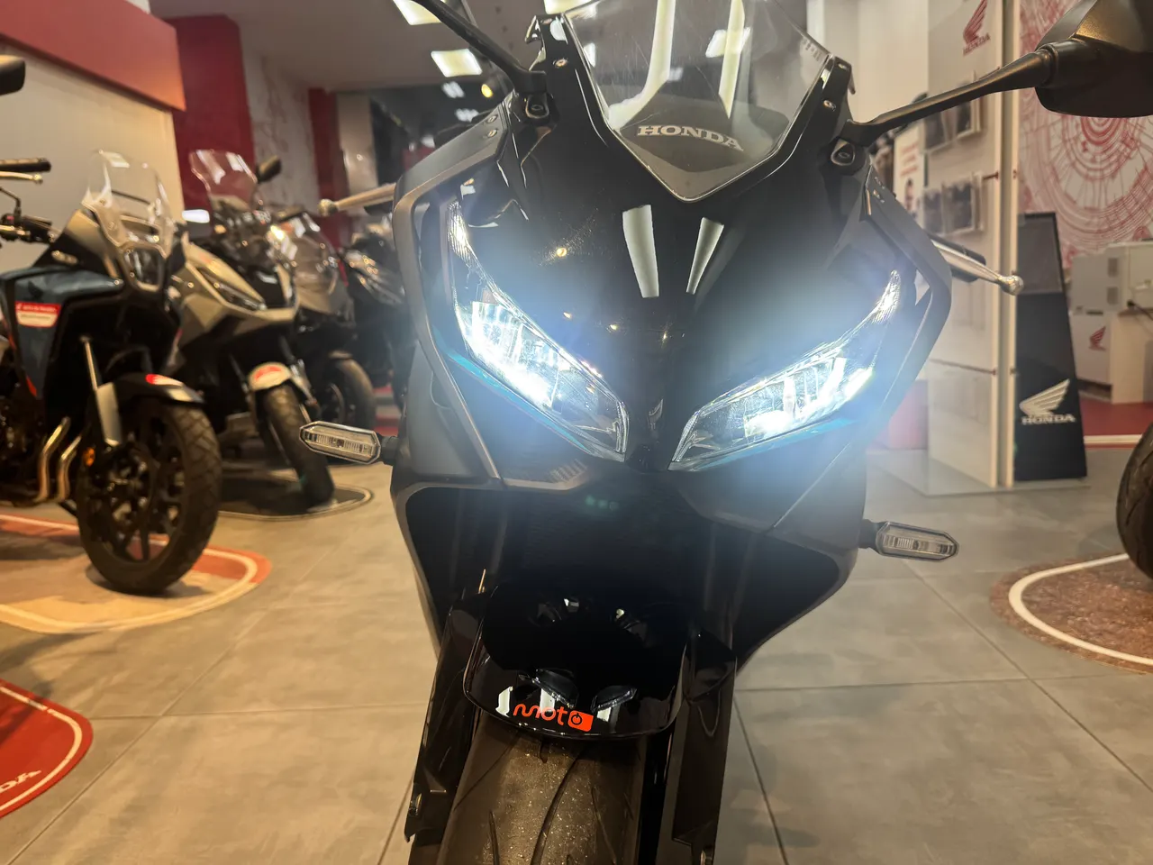 Vista frontal de una moto Honda CBR650R negra con luces encendidas