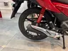 Detalle del escape, llanta trasera y amortiguador de una Honda CB125F roja R-355.
