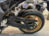 Detalle de la rueda trasera dorada y cadena de una Honda Hornet 1000 SP