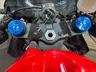 Detalle del manillar de una Honda CBR 600RR roja con tapas de suspensión azules.