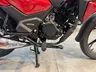Detalle del motor y partes inferiores de una moto Honda CB125F de color rojo.