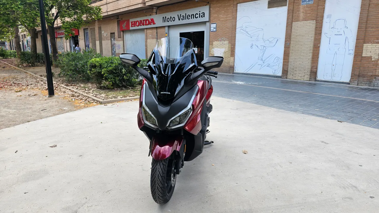 Scooter Honda Forza 350 rojo carnelian mate en la ciudad