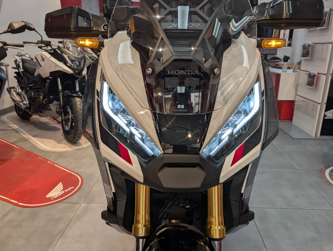 Vista frontal de una moto Honda X-adv 750 ocasion con luces LED encendidas