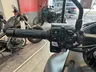 Detalle del manillar de una motocicleta con varios botones de control y puño.