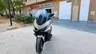 Honda Forza 750 gris mate estacionada frente a concesionario