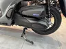 Detalle del motor y rueda trasera de una Honda SH 350i gris