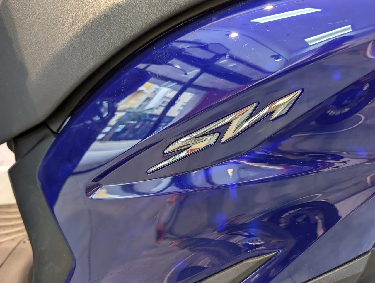 Lateral de Honda SH125i azul brillante con emblema SH cromado