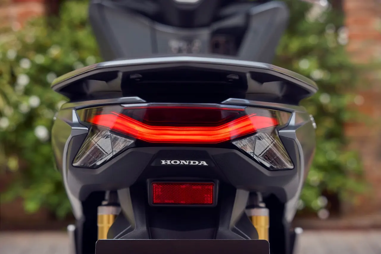 Vista trasera de la scooter Honda PCX 125 gris oscuro con luz trasera LED encendida