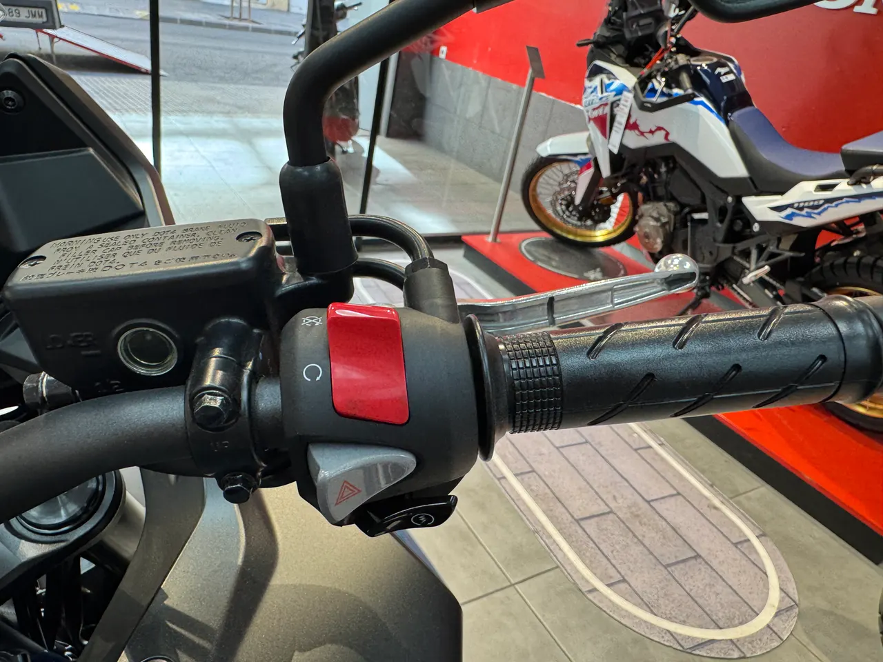Manillar izquierdo de la Honda NX500 E-Clutch con controles y depósito de freno.