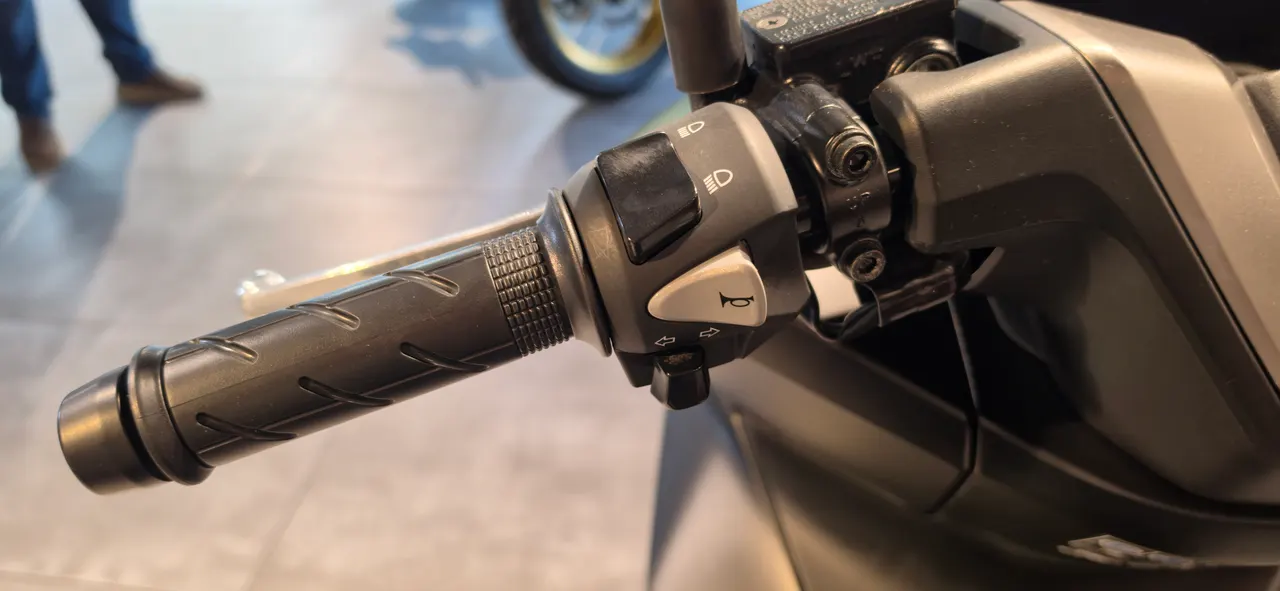 Detalle del manillar de una Honda PCX 125 con controles de luces y claxon