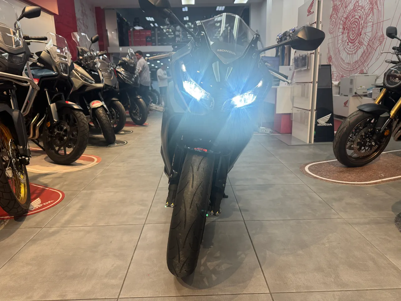 Vista frontal de una motocicleta deportiva Honda negra con luces encendidas