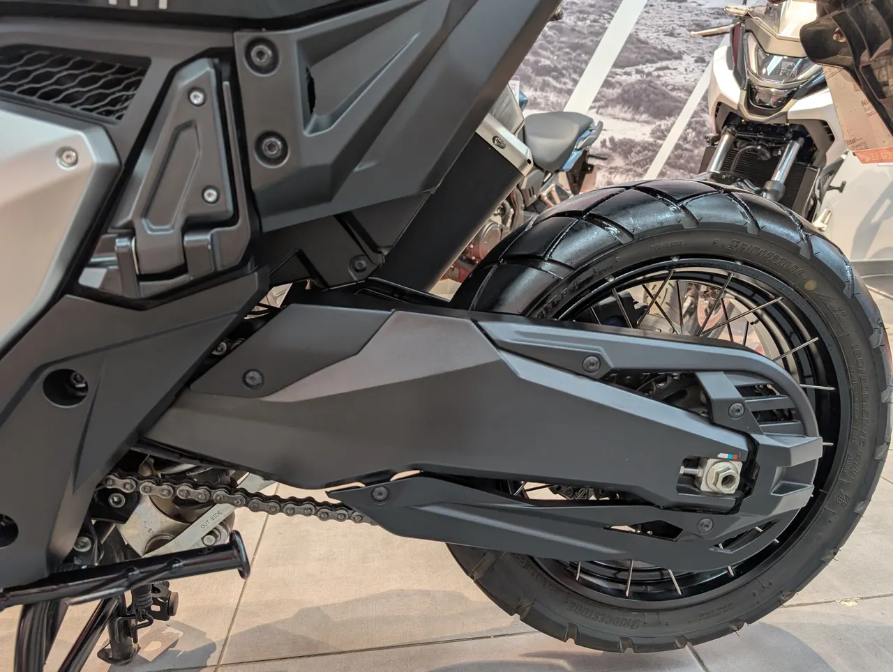 Detalle de la rueda trasera y cadena de una moto Honda X-adv
