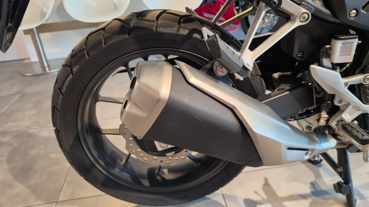 Detalle de la rueda trasera y el sistema de escape de una moto Honda NX500.