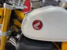 Detalle del depósito blanco y horquilla amarilla de una Honda Monkey.
