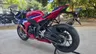 Moto Honda CBR1000RR-R Fireblade SP roja, blanca y azul aparcada en exterior.