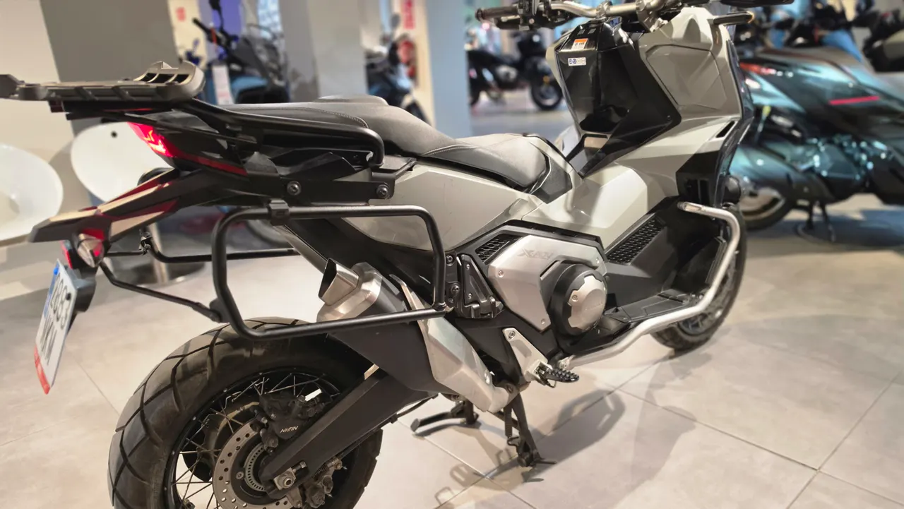 Vista trasera de una moto Honda X-ADV gris con maletas laterales
