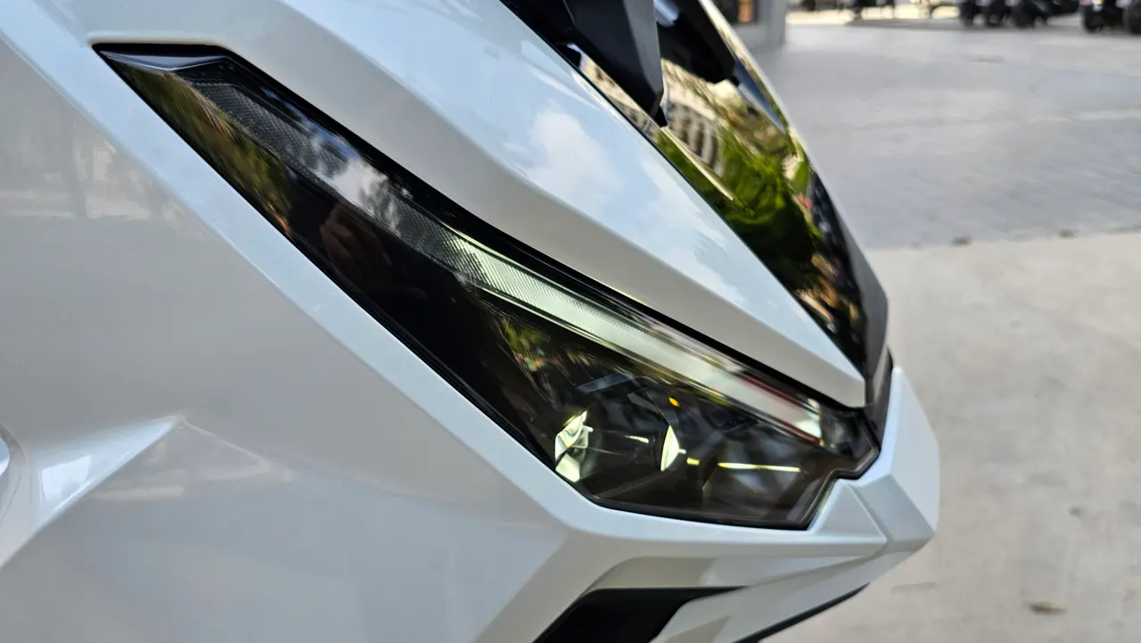 Detalle del faro delantero de una moto Honda X-ADV blanca.