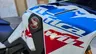 Detalle del lateral de la Honda Africa Twin CRF1100L blanca con gráficos azules y rojos