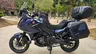 Moto Honda NT1100 azul oscuro con maletas laterales y top case, estacionada en un parque.