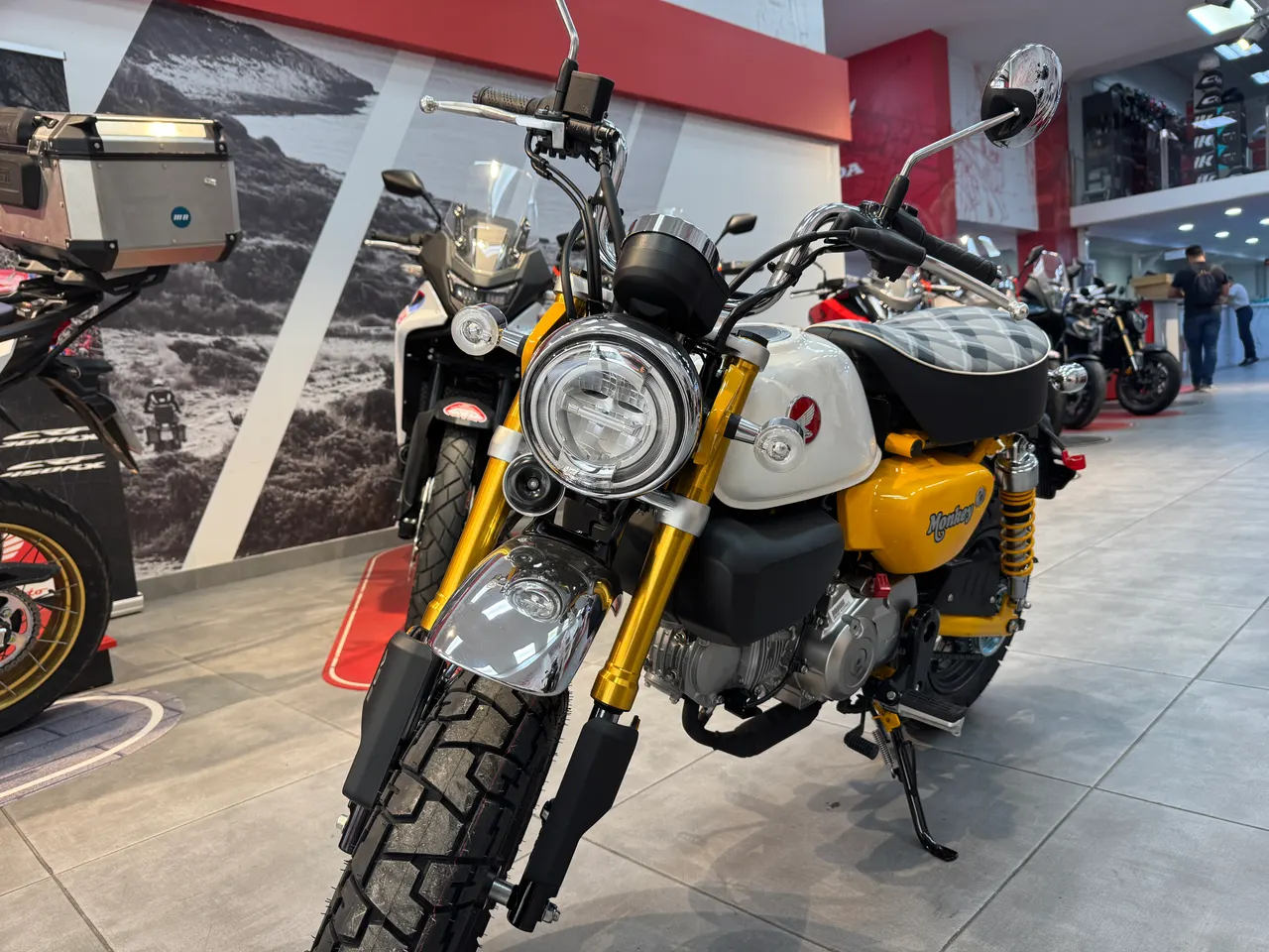 Honda Monkey amarilla y blanca en exposición