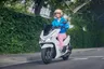 Mujer sonriente en scooter Honda PCX 125 blanca