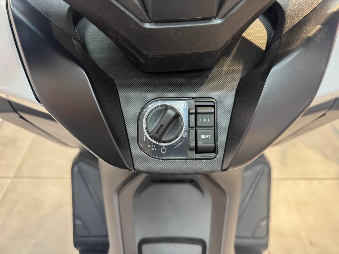 Consola central con sistema de arranque sin llave de la scooter Honda Forza 125 en color blanco.
