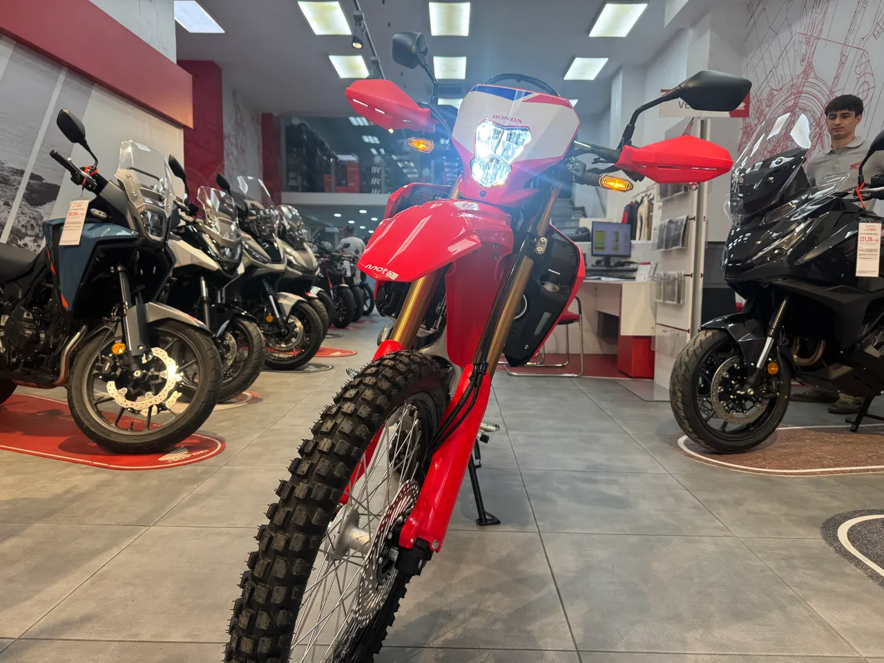 Honda CRF300L roja con faro led encendido en exposición