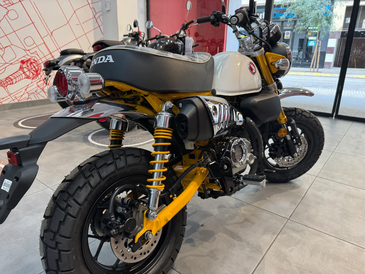 Honda Monkey amarilla y blanca en exposición