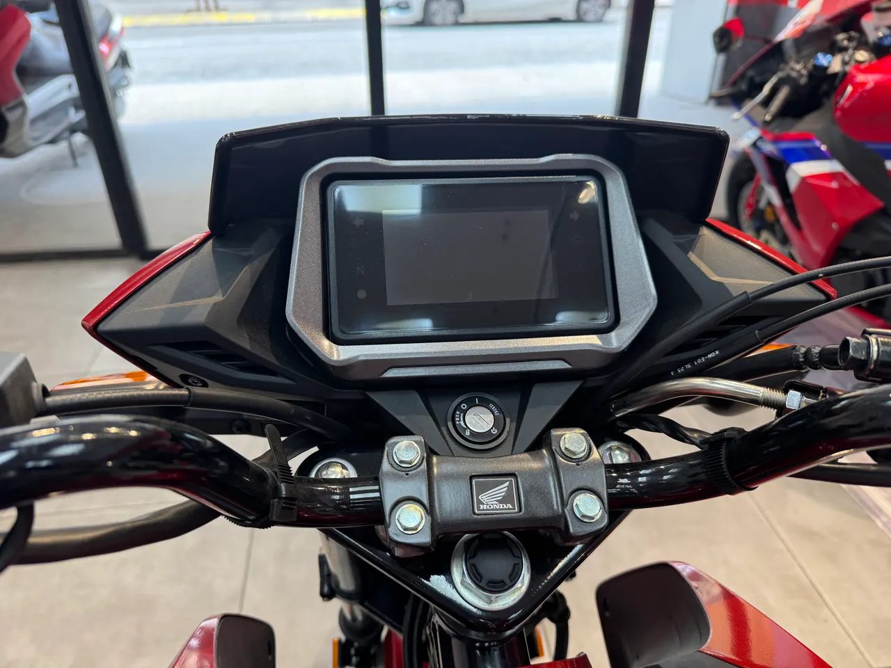 Cuadro de instrumentos digital de una moto Honda CB125F de color rojo.