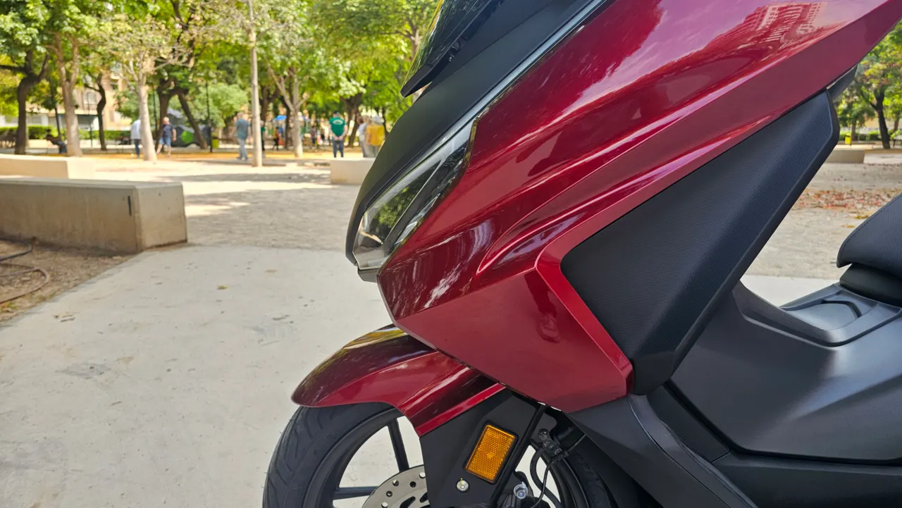 Scooter Honda Forza 350 rojo carnelian en un parque