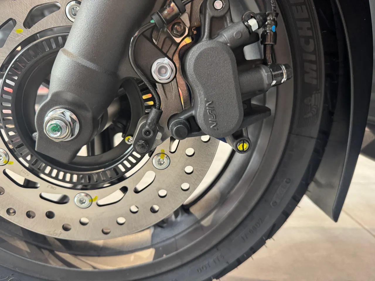 Freno de disco delantero de la Honda Forza 125 con pinza Nissin y neumático Michelin.