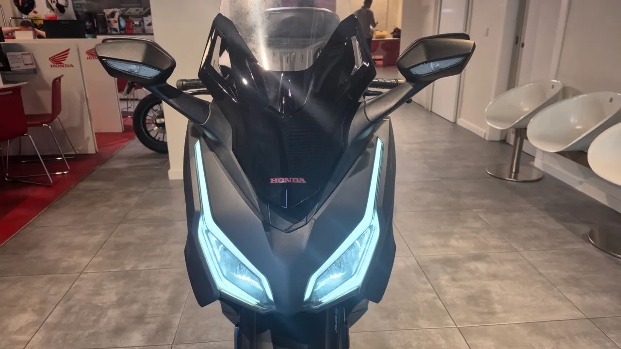 Vista frontal de una Honda Forza 125 Ocasion negra con luces LED encendidas