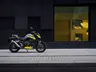 Honda CB750 Hornet gris y amarilla aparcada junto a edificio moderno